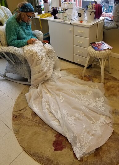 Lavender House Owner and seamstress Toni DePalma altering a wedding gown